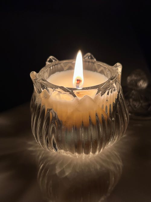 A Lighted Candle in a Clear Glass Container