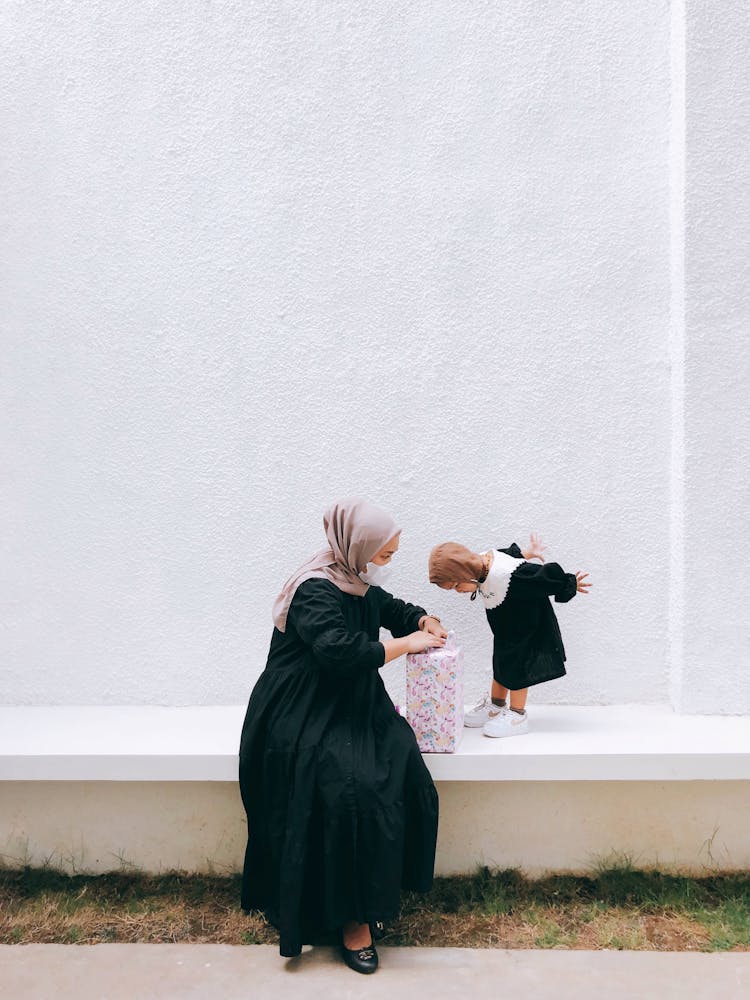 Hijabi Woman Opening Present For Her Daughter