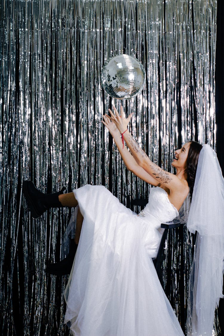 Woman In Wedding Dress Throwing Disco Ball