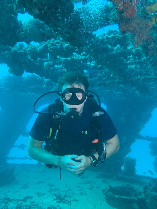 A Man in Black Shirt Swimming Underwater