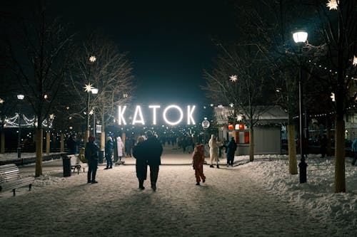 People Walking on Snow Covered Ground during Night Time