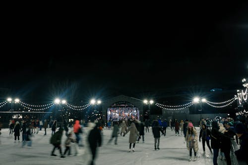 People Skating on the Rink at Night