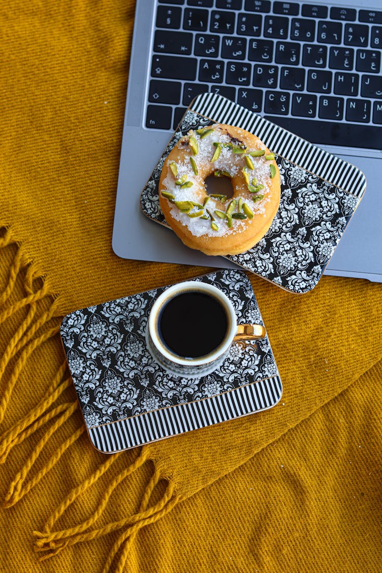 Coffee Cup And Bagel On Laptop