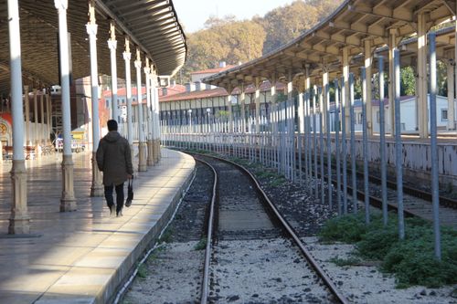 Free Person in gray coat walking on an empty railway station platform in Istanbul. Stock Photo