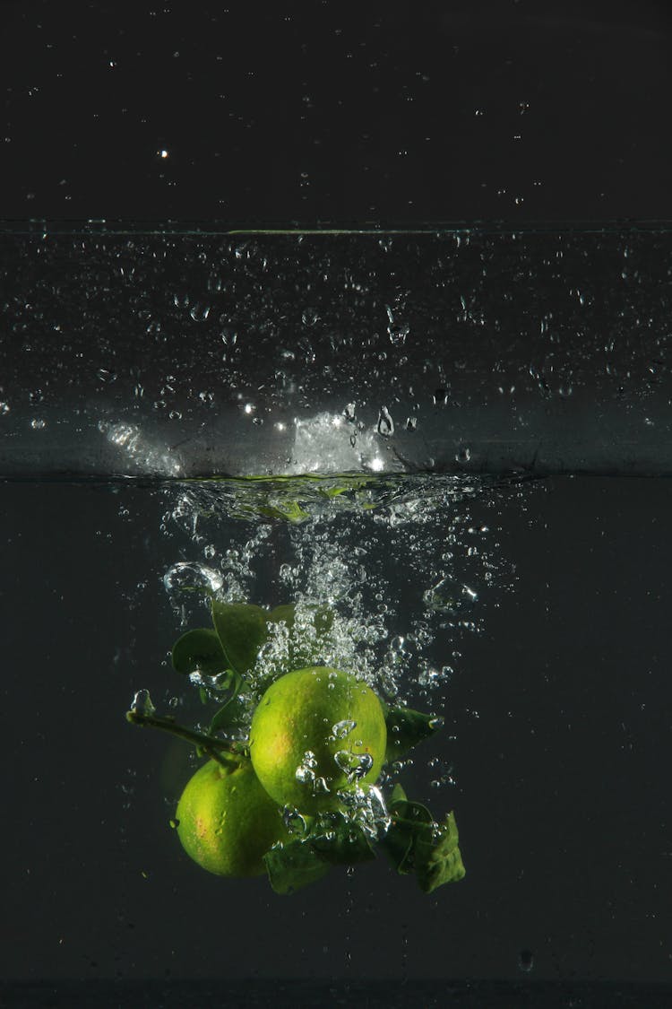 Green Apples Falling Into Water With A Splash 