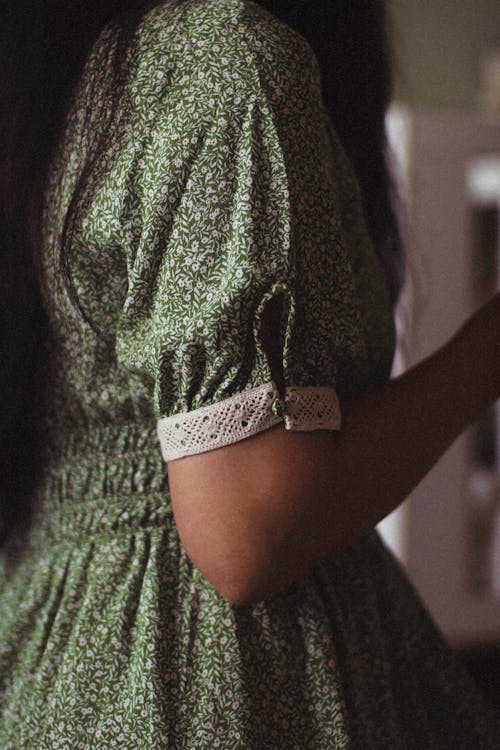 A Close-up Shot of a Woman in Green Printed Dress