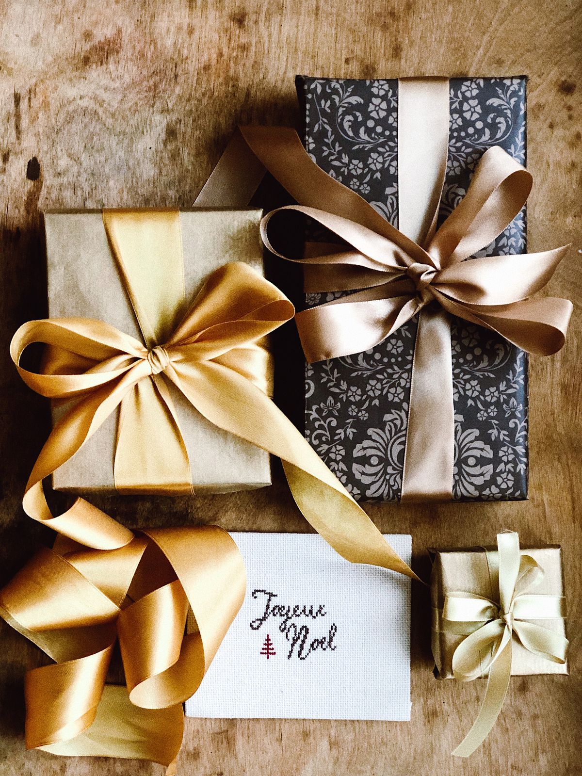 Presents wrapped in patterned gold and cream paper, flat lay.