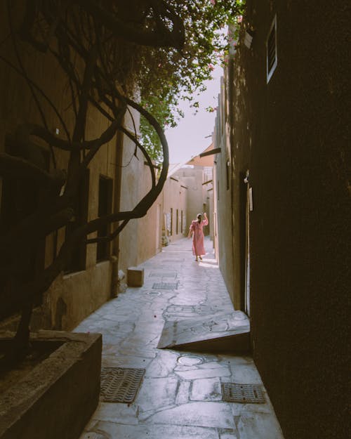 Back View of a Woman Walking on the Alleyway