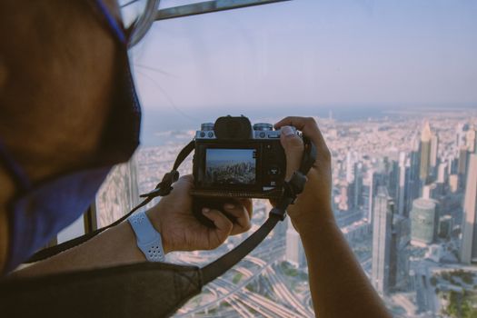 Photographer takes a shot of the iconic Dubai skyline from a high vantage point.