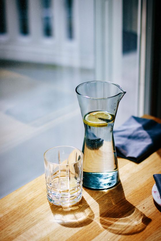 Tall glass carafe and tumbler on a sunlit table — photo by Kristina Paukshtite on Pexels