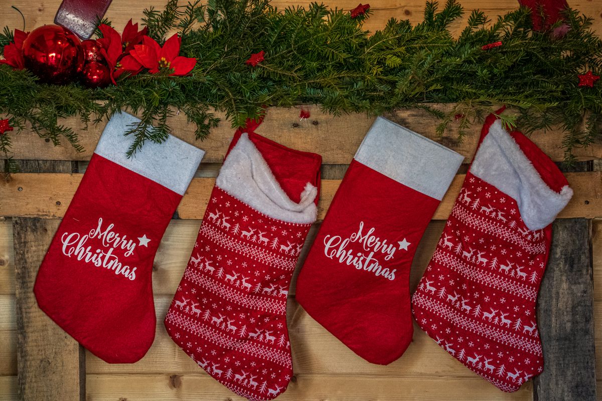 Row of red Christmas stockings hanging with greenery