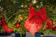 A vibrant Christmas wreath adorned with red bows and ornaments, perfect for holiday decoration.