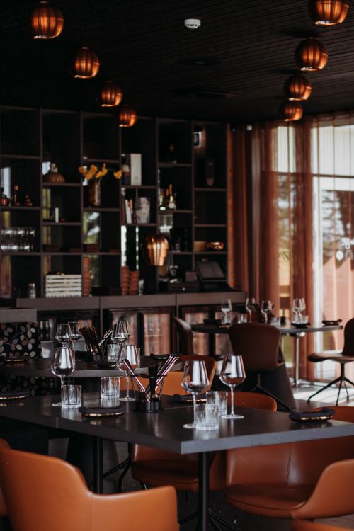 Free A chic and modern restaurant interior with stylish decor and mood lighting, set for dining. Stock Photo