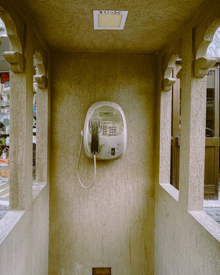 Wired Street Telephone Hanging On Wall