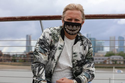 A Man in Printed Jacket Looking while Wearing Face Mask