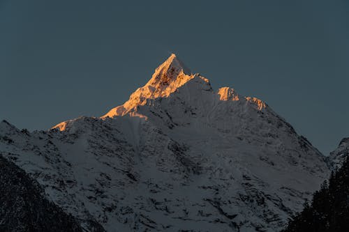 A Snow Covered Mountain Under the Dark Sky