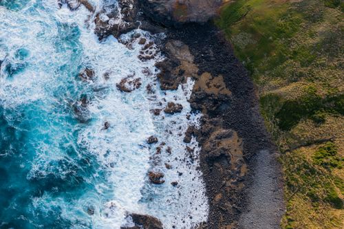 Free Stunning aerial shot of rocky coastline with crashing waves in Victoria, Australia. Stock Photo