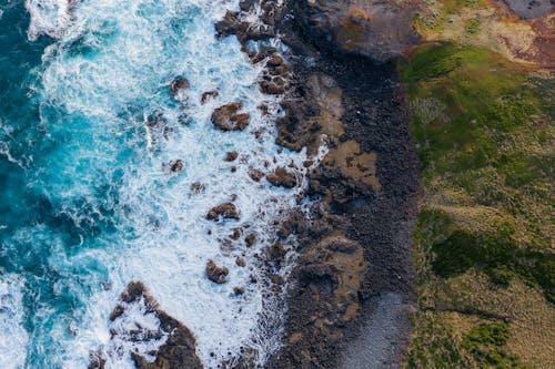 Aerial View of Ocean Waves Crashing on Rocks