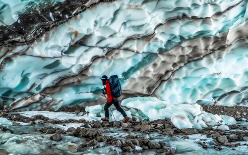 Free A lone hiker treks through a stunning glacier landscape in Yunnan, China, capturing nature's beauty. Stock Photo