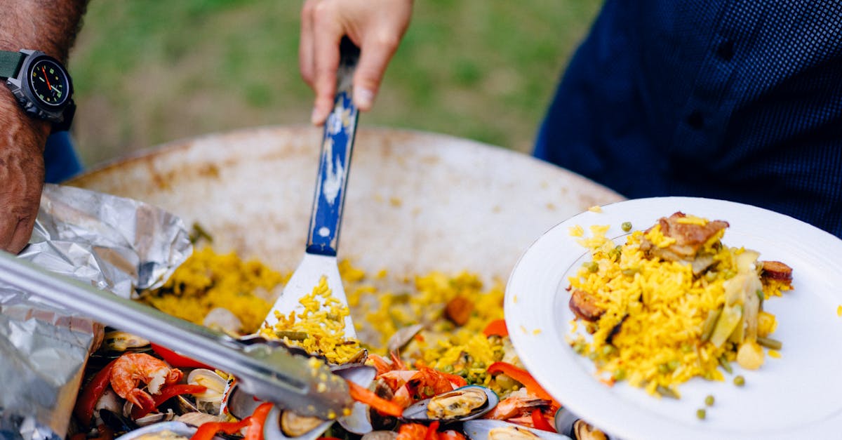 Spanish cheese and cured meats platter on a wooden board with olives, bread, and wine glasses.