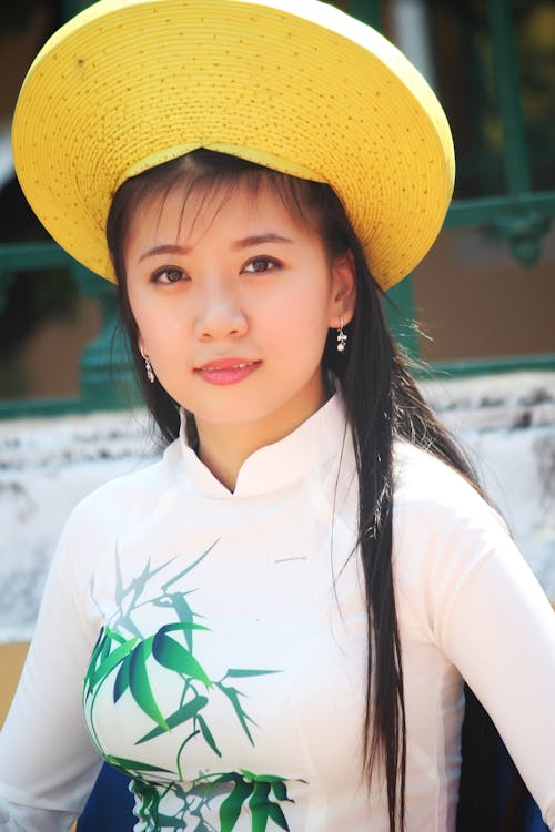 Wanita Berkemeja Putih Lengan Panjang Dan Topi Kuning