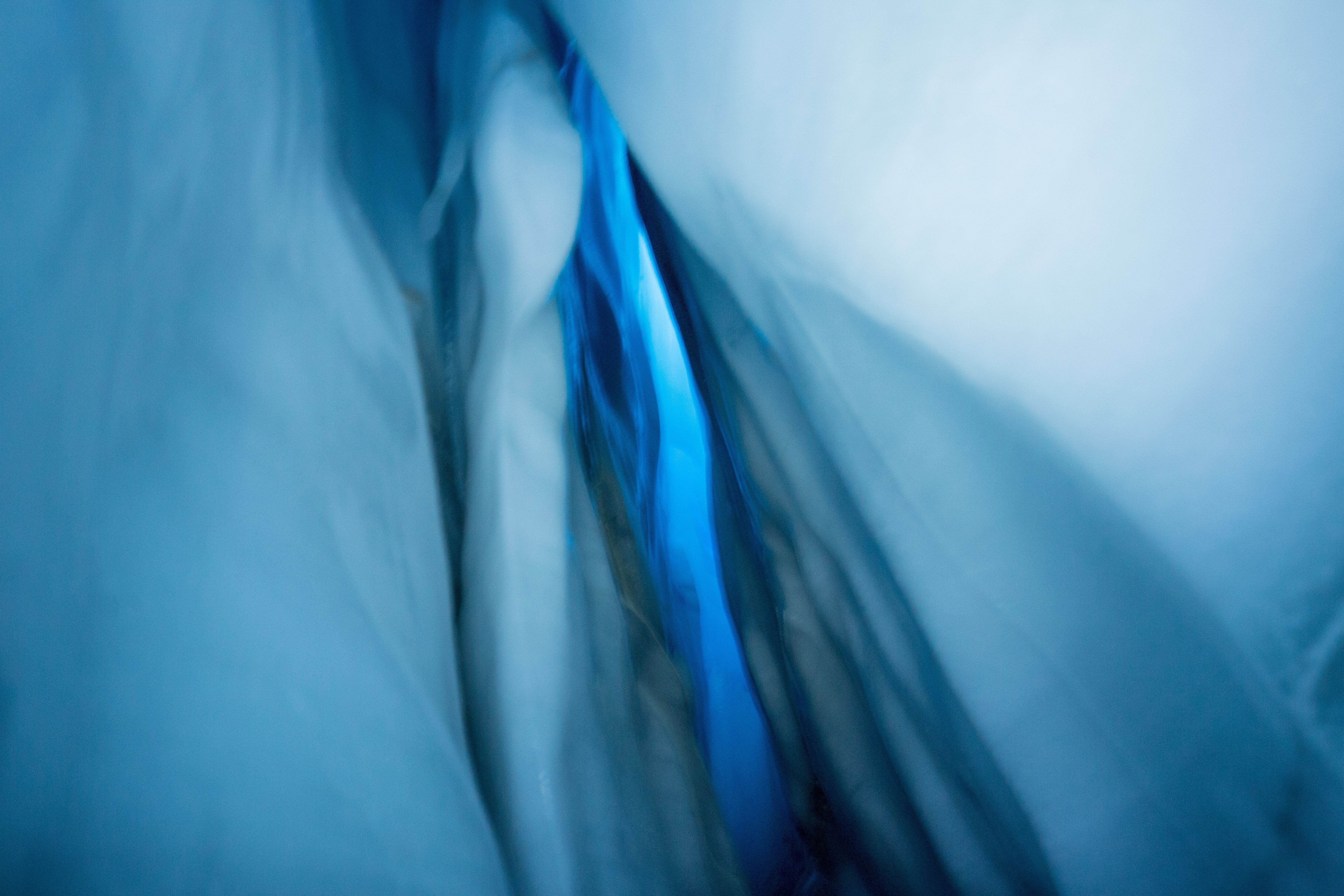 Helicopter and Glacier Paddle Boarding -PRIVATE - A mesmerizing abstract view inside an ice cave showcasing frozen textures in cool blue tones.