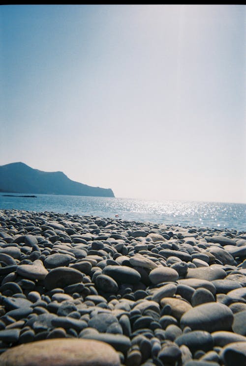 A Stones Near the Body of Water Under the Clear Sky