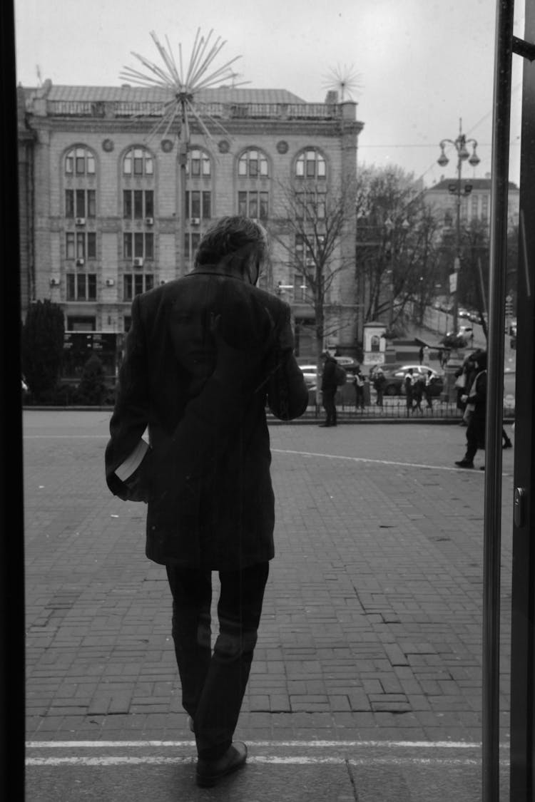 Back View Of A Person Walking While Carrying A Book