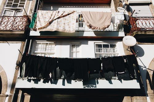 Close Up Photo of Black Clothes Hanged Outside Window