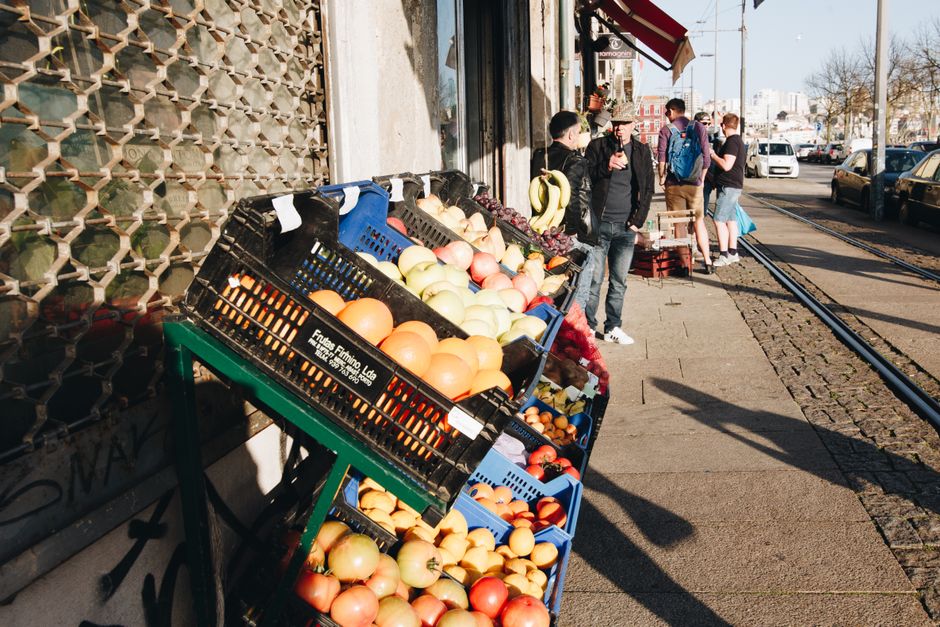 Vibrant street market in Porto featuring fresh fruits and casual shoppers on a sunny day. — Bolhão, Portugal.
