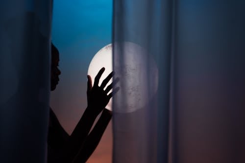 Silhouette of Woman Holding Moon
