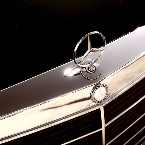 Free A Silver Mercedes Benz Emblem on a Car Hood Stock Photo