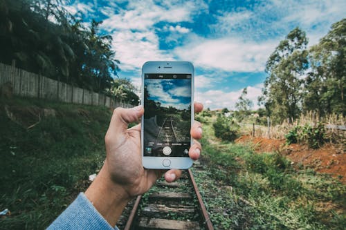 человек, держащий серебряный Iphone 6 с фотографией