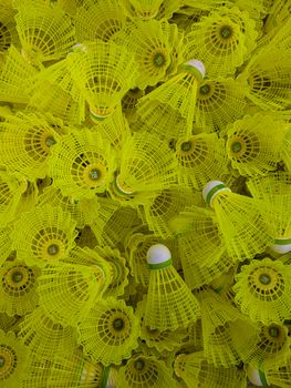 Close-up of vibrant yellow badminton shuttlecocks in a dynamic arrangement, showcasing sporting equipment.