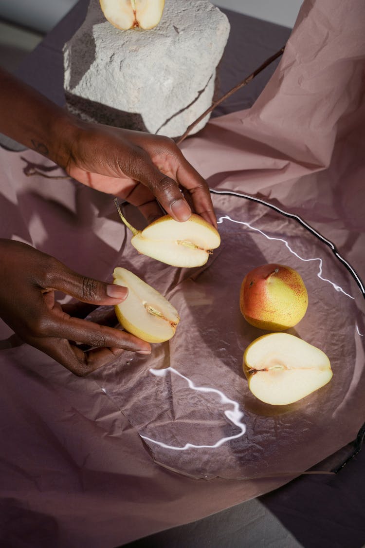 Hands Putting Cut Pears On Dish