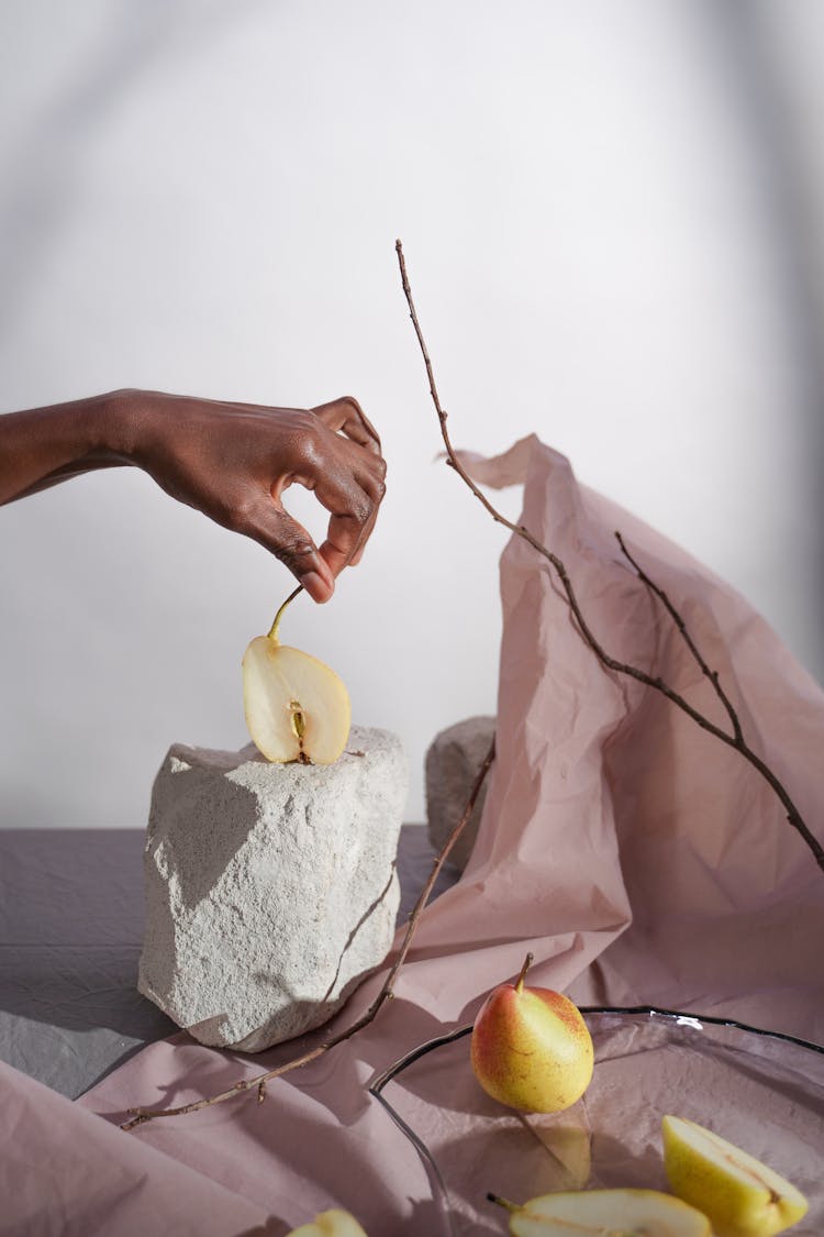 Hand Putting Cut Pear On Stone