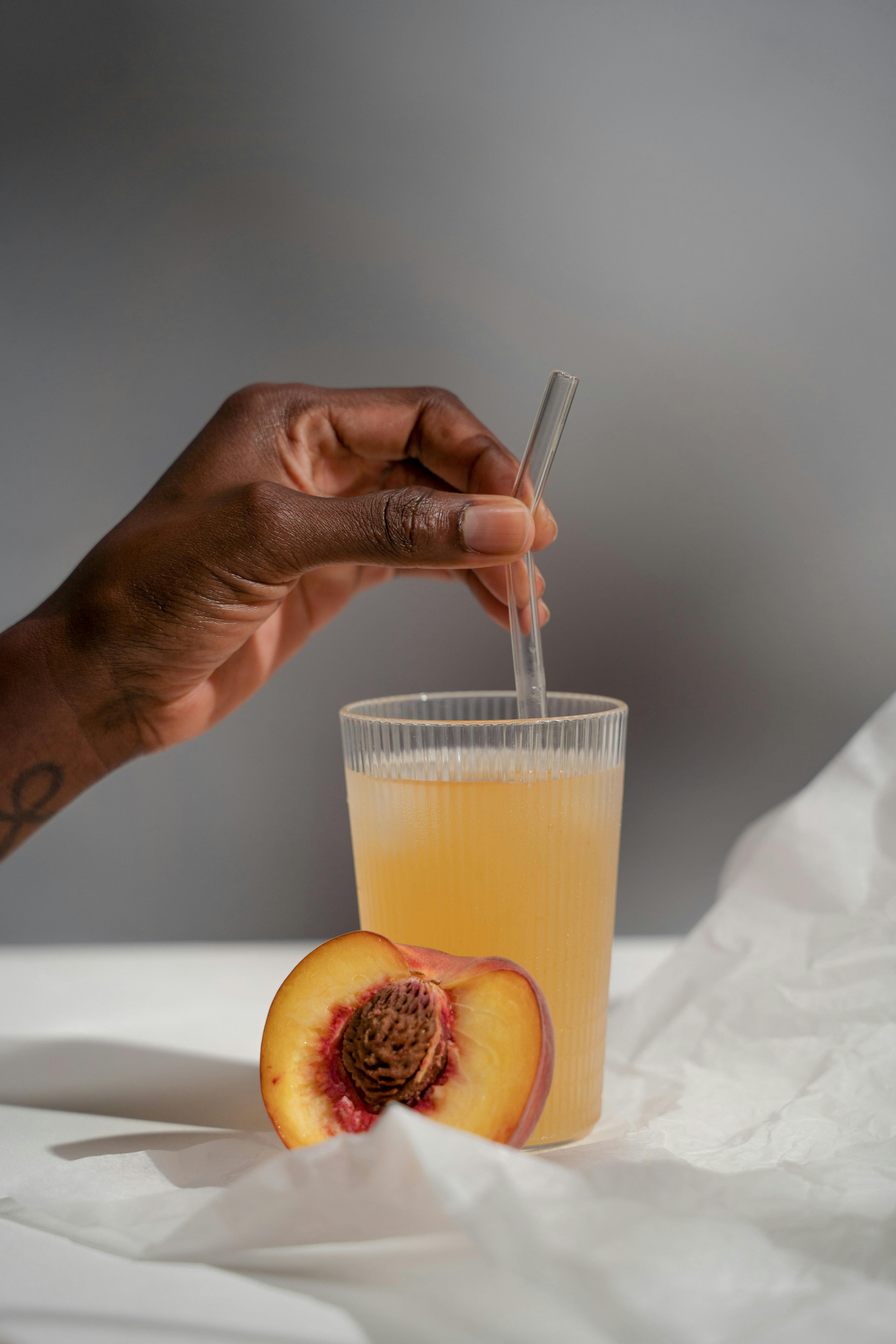 Hand Holding Straw in Juice · Free Stock Photo