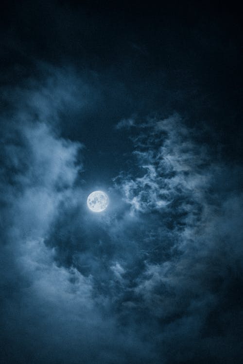 Free Bright Moon surrounded by Clouds  Stock Photo