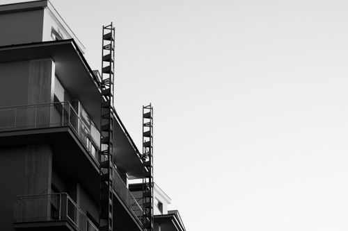 Free Black and white photo of a modern apartment building against a clear sky. Stock Photo