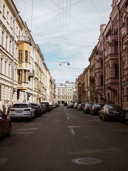 Elegant European street scene with parked cars and classic architecture in daylight.