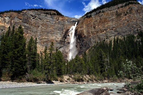 A Waterfalls Between the Rock Formations Near the Green Trees