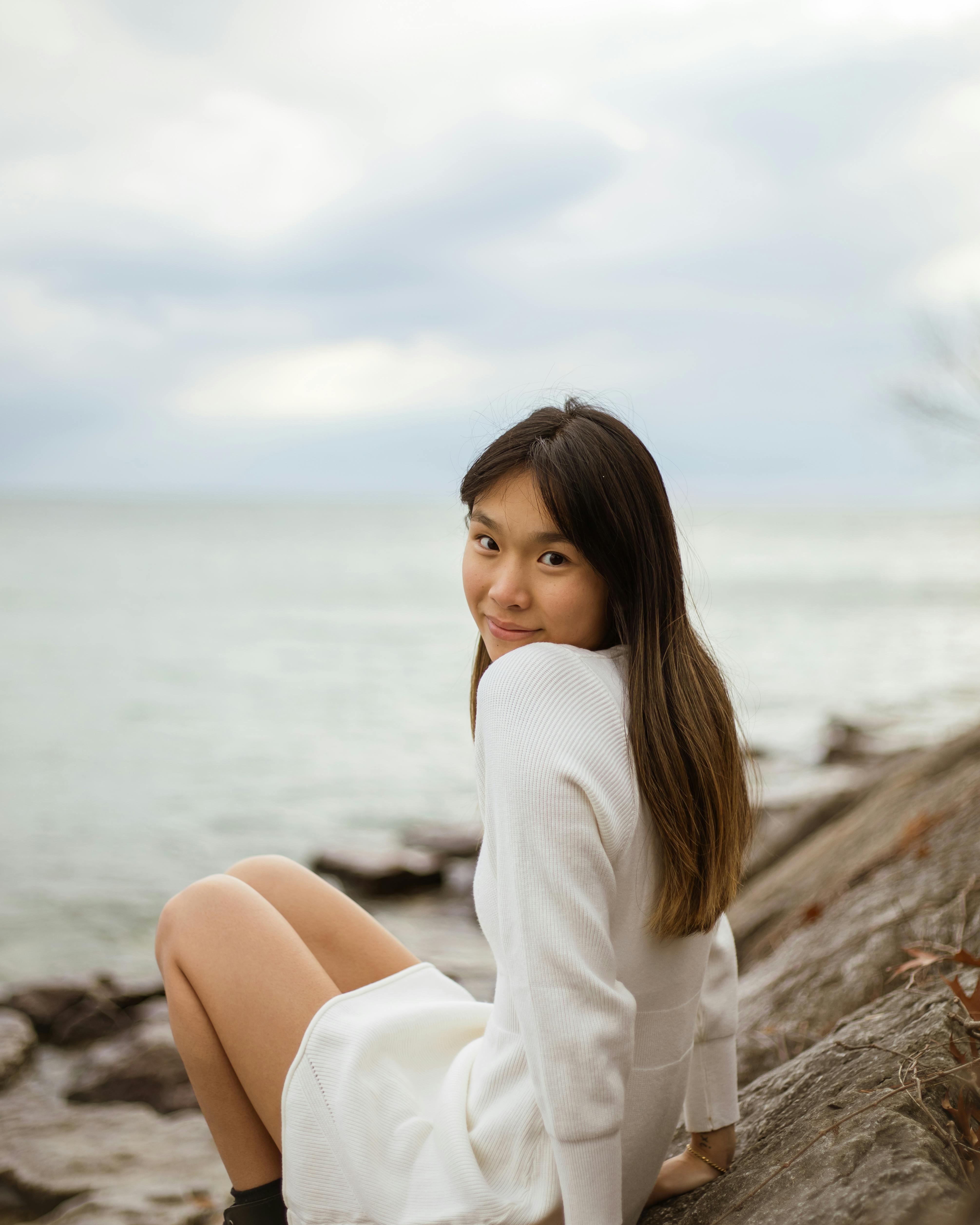 woman sitting on rock and looking over shoulder