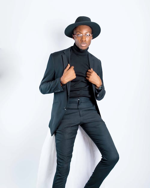A Portrait of Male Model Wearing Black Suit, Hat and Glasses During Photoshoot