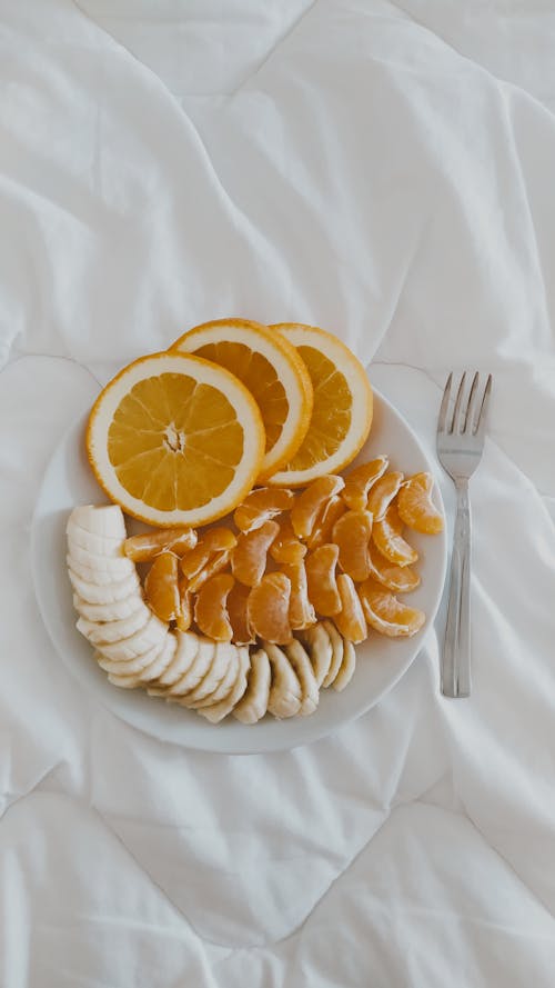Sliced Orange Fruit on White Ceramic Plate