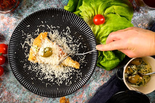 Italian Food being Sliced with a Fork by a Person 