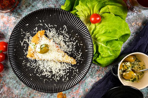 Free Deliciously plated Italian focaccia slice topped with cheese and olives, perfect for gourmet enthusiasts. Stock Photo