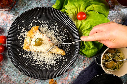 Italian Food being Sliced with a Fork by a Person 