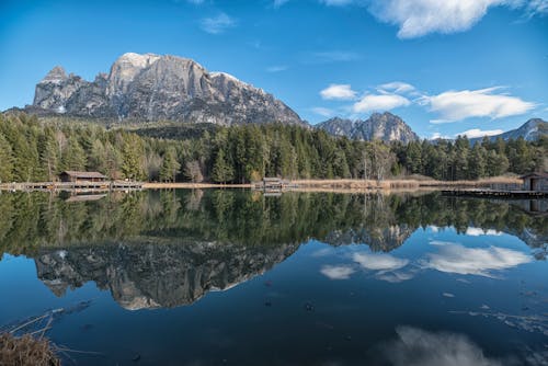 Calm Lake near Green Trees and Mountains under the Blue Sky