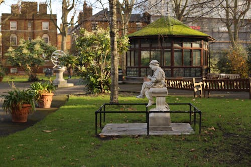 White Concrete Statue on Green Grass Field in the Park