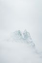 Snowcapped Mountain Peak Obscured by Clouds